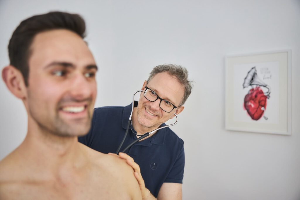 Verhalten nach Herz OP: Dr. Moser behandelt einen Patienten in seinem Behandlungszimmer